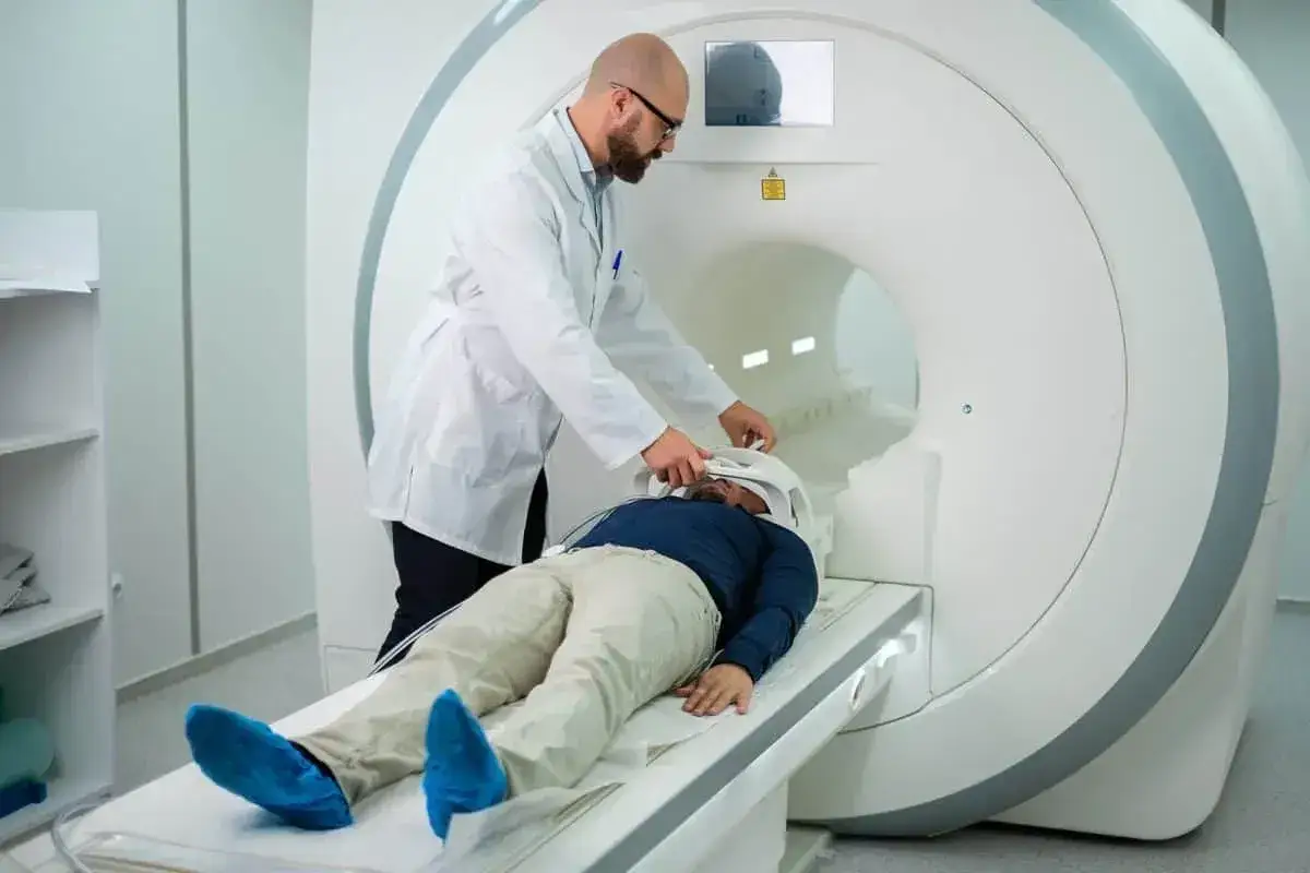 Lekarz przygotowuje pacjenta do rezonansu magnetycznego. Pytanie, czy na rezonans magnetyczny można mieć hybrydy, jest kluczowe dla bezpieczeństwa.