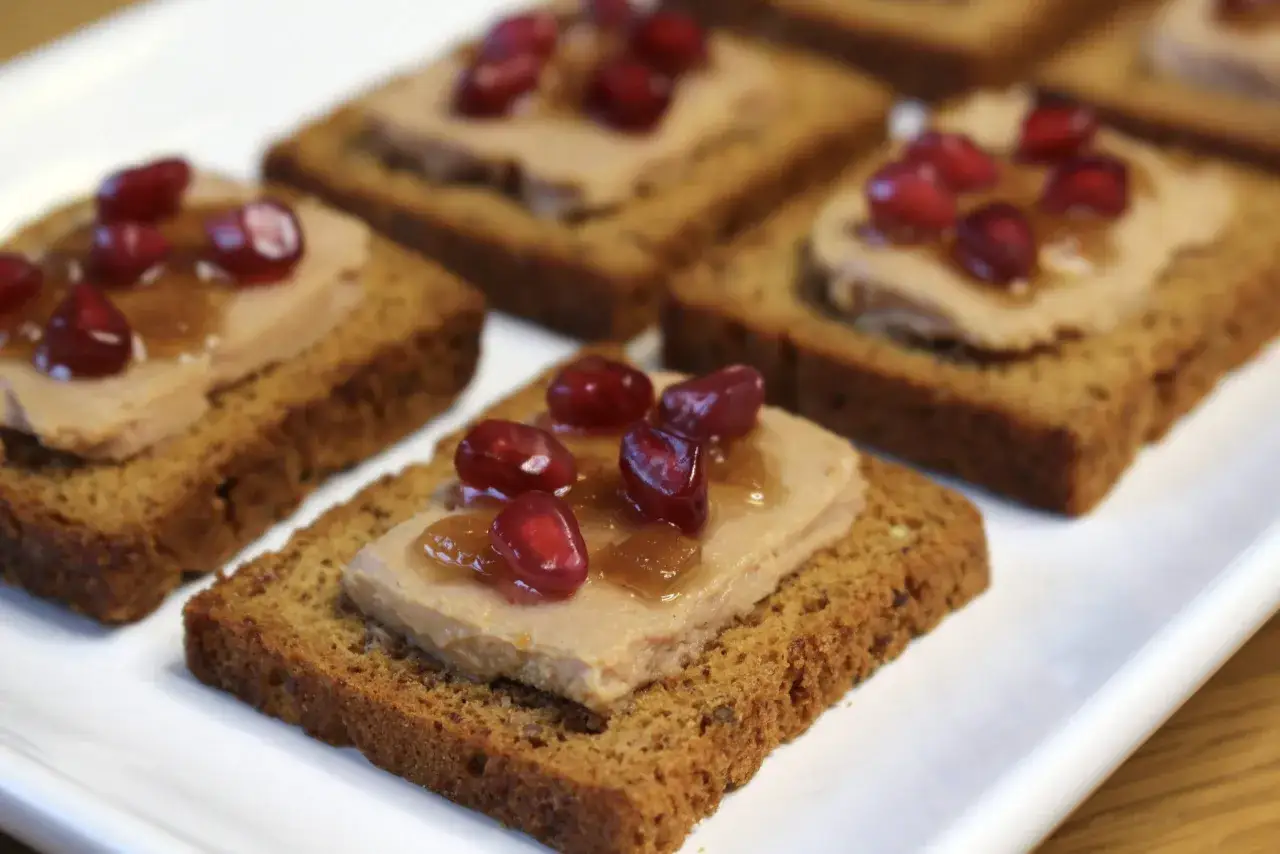 Toast original au foie gras, garni de grains de grenade et d'une touche de confiture. Un délice pour les papilles.