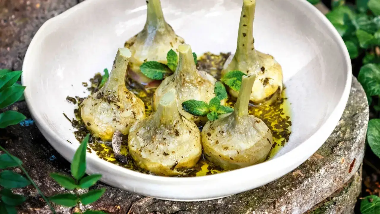 Cinq c&oelig;urs d'artichauts brais&eacute;s, napp&eacute;s d'une huile parfum&eacute;e et garnis de menthe fra&icirc;che. Une recette artichaut simple et savoureuse.