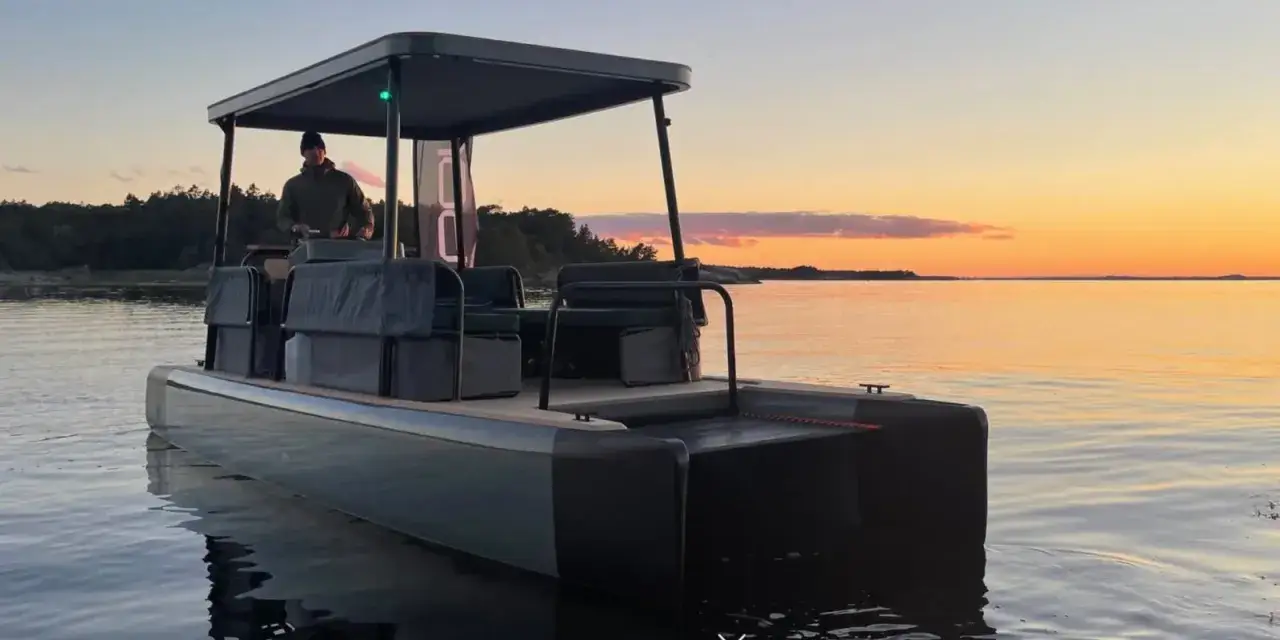 Ein Mann steuert ein modernes Boot mit Sonnendach über ruhiges Wasser bei Sonnenuntergang. Diese solar boote sind perfekt für entspannte Ausflüge.