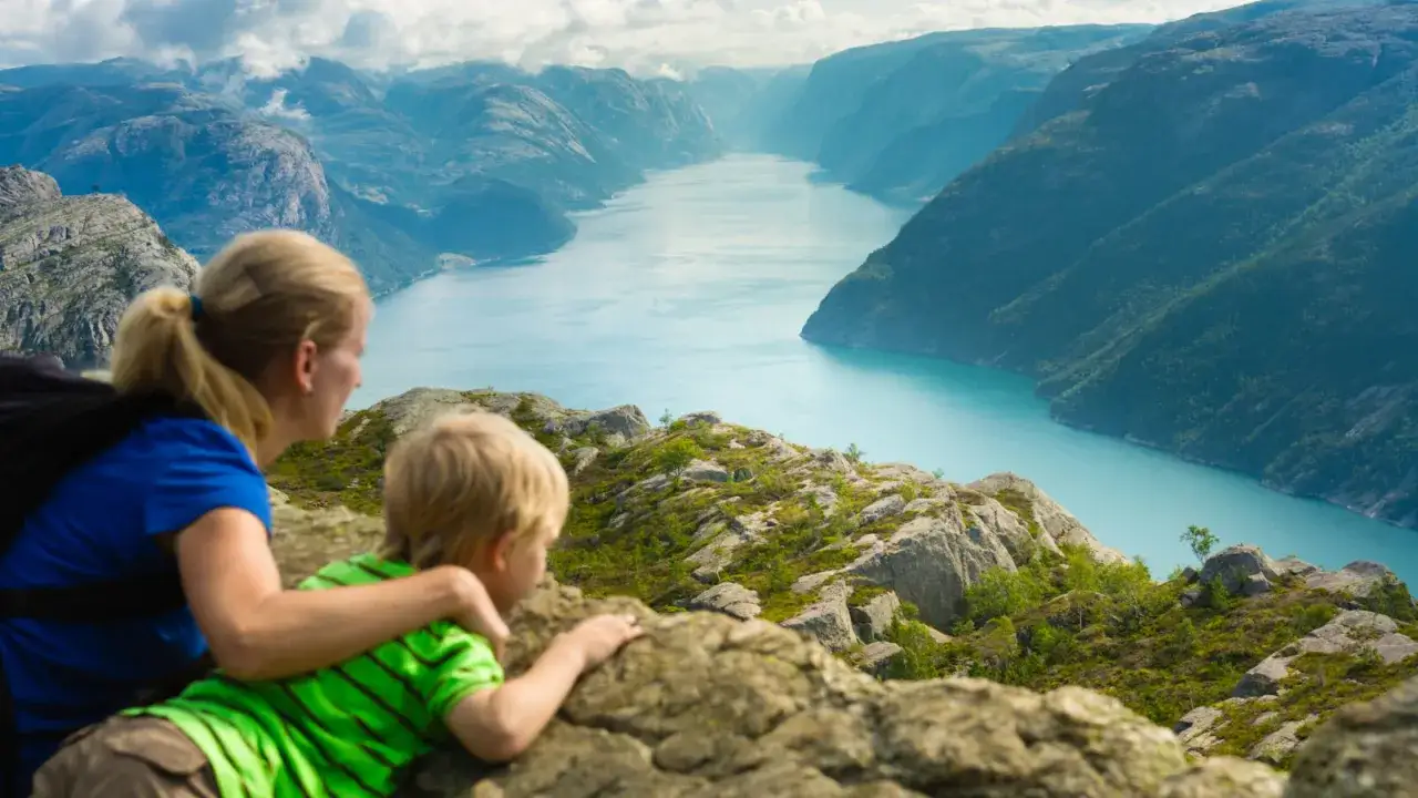 Mama i syn podziwiają zapierający dech w piersiach widok na fiord w Norwegii. Niezapomniane chwile z dziećmi.