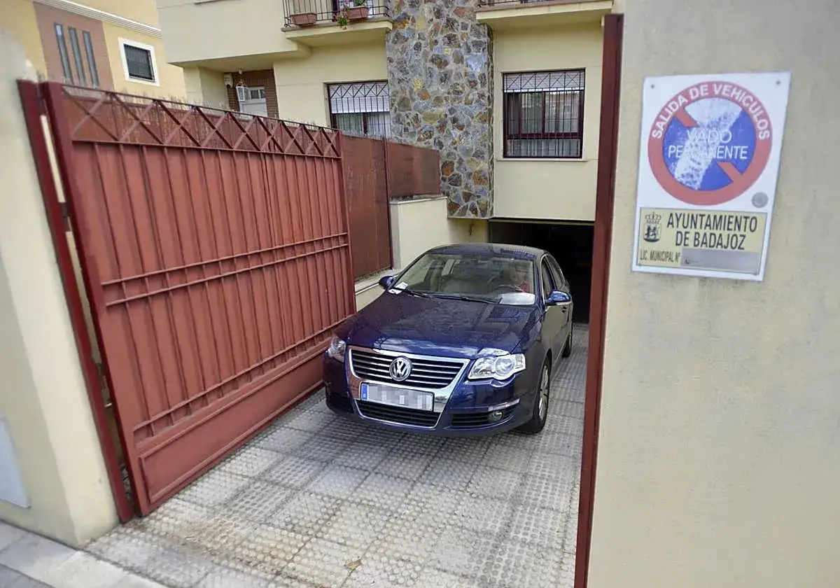 Un coche azul est&aacute; aparcado en una cochera. Hay un cartel que indica 
