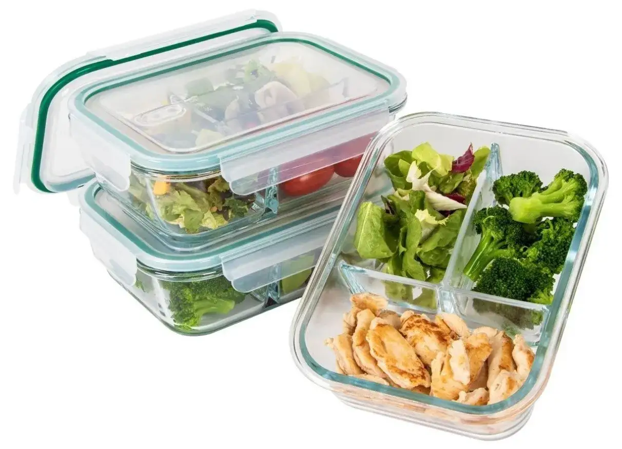 Szklane pojemniki na żywność z przegródkami, wypełnione kurczakiem, sałatką i brokułami. Idealne do zdrowego lunchboxa.