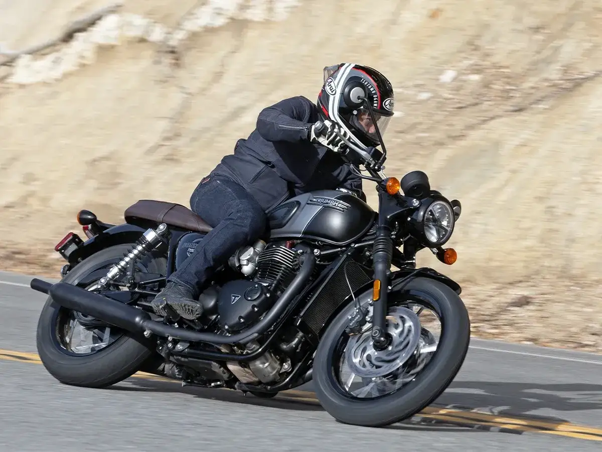 Motocyklista na Triumph Bonneville T120, zwinny na drodze. Dane techniczne tego klasyka zachwycają.