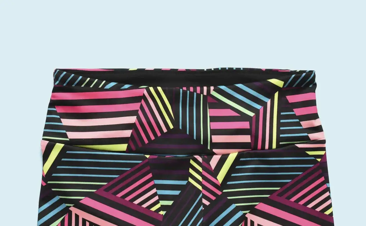 Close-up of colorful, geometric-patterned yoga pants, showing the waistband and fabric detail.