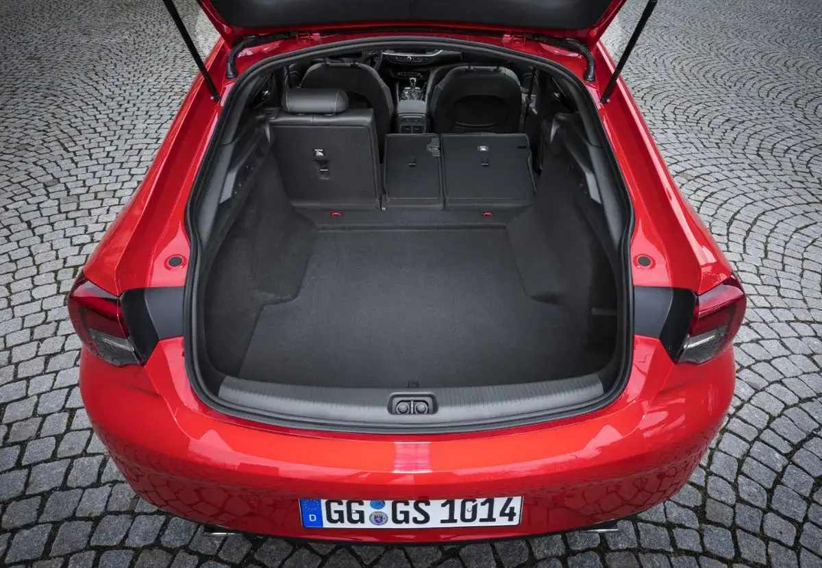 Czerwony Opel Insignia z otwartym bagażnikiem. Duża przestrzeń bagażowa, idealna na wakacyjne wyjazdy. Sprawdź opel insignia pojemność bagażnika.