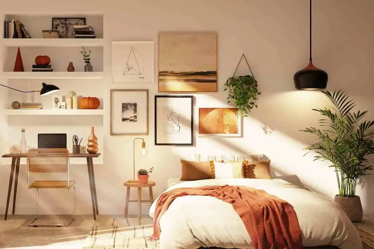 Acogedor dormitorio sin cabecero, con cama vestida, escritorio, plantas y arte en las paredes.