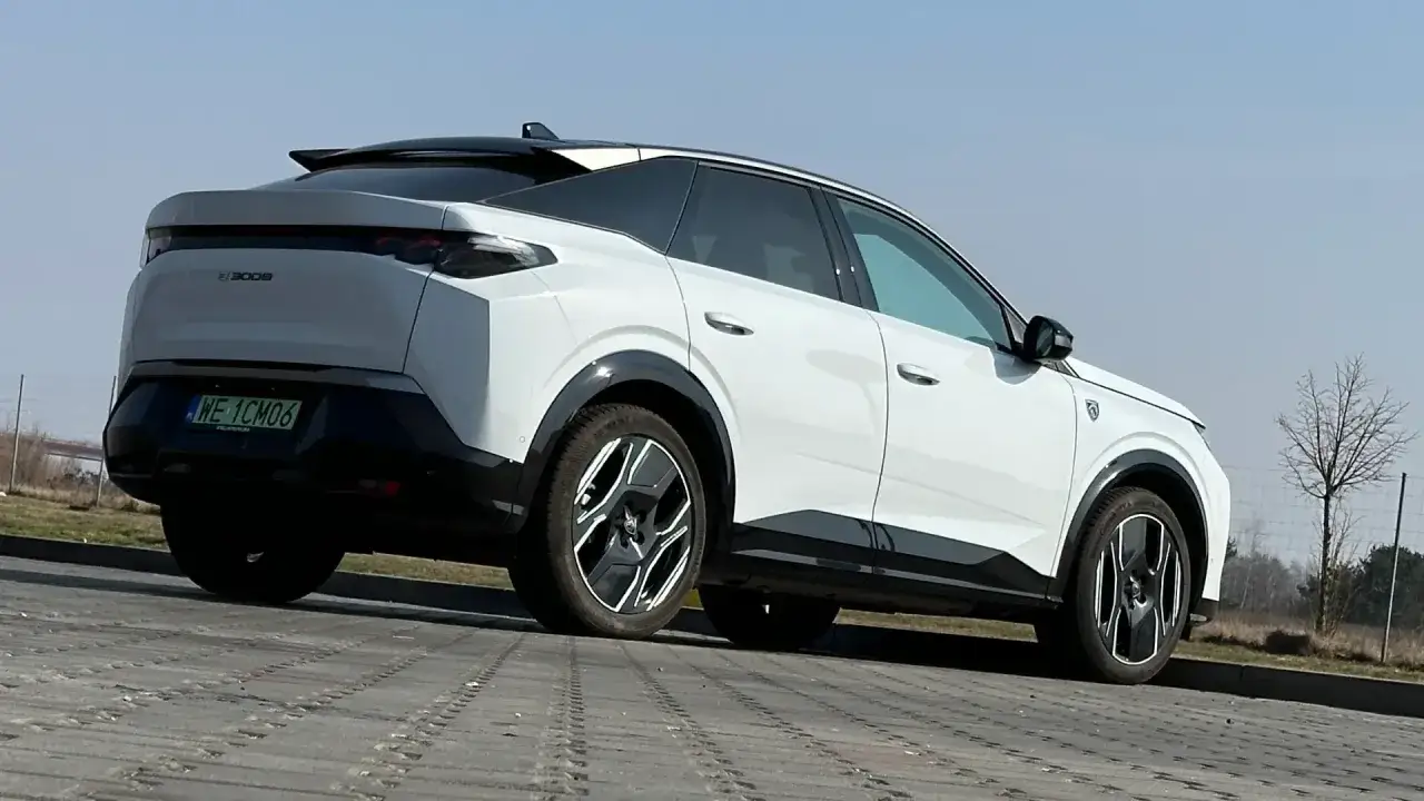 Nowy, biały Peugeot 3008 elektryczny z czarnymi detalami i nowoczesnymi felgami stoi na parkingu.