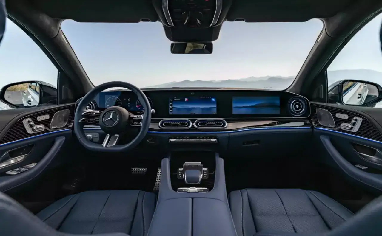 Wnętrze luksusowego **Mercedes GLE 450** z niebieską skórzaną tapicerką, nowoczesnym kokpitem i dwoma dużymi ekranami.