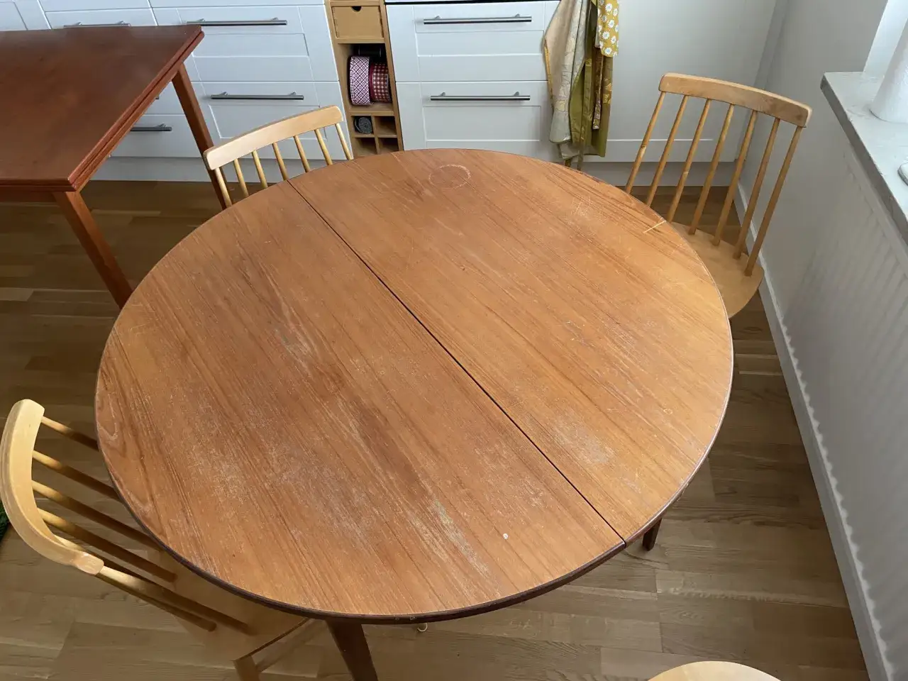 Runt matbord i tr&auml; med stolar. Bordet beh&ouml;ver behandla furubord f&ouml;r att f&aring; tillbaka sin glans.