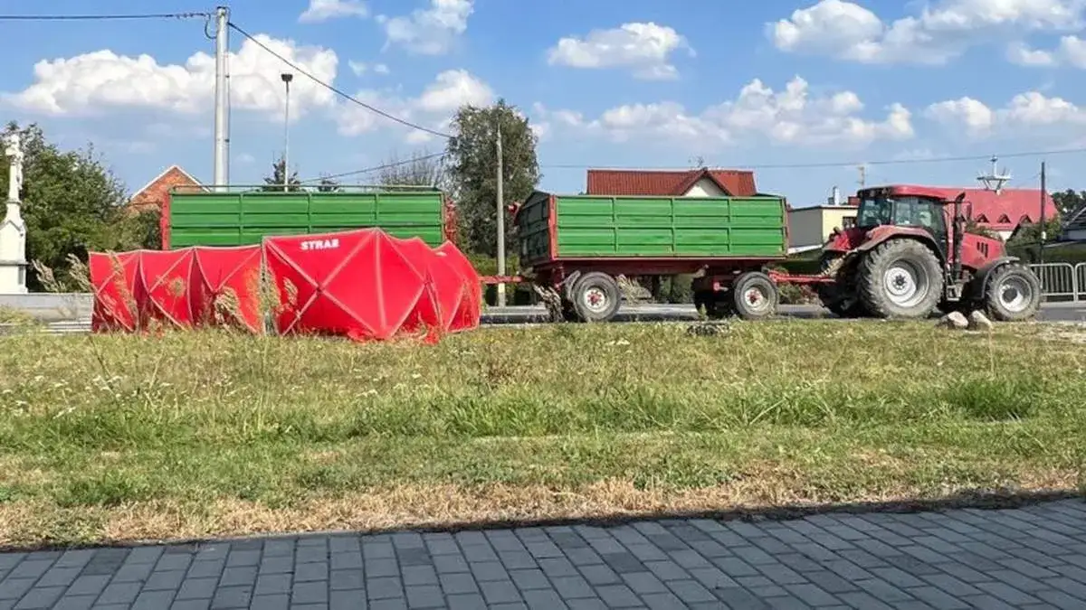 ciągnik rolniczy z dwoma przyczepami na drodze