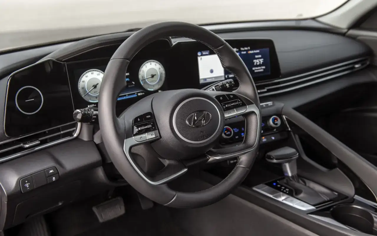 Wnętrze Hyundai Elantra 2023: kierownica, cyfrowe zegary i ekran multimediów.