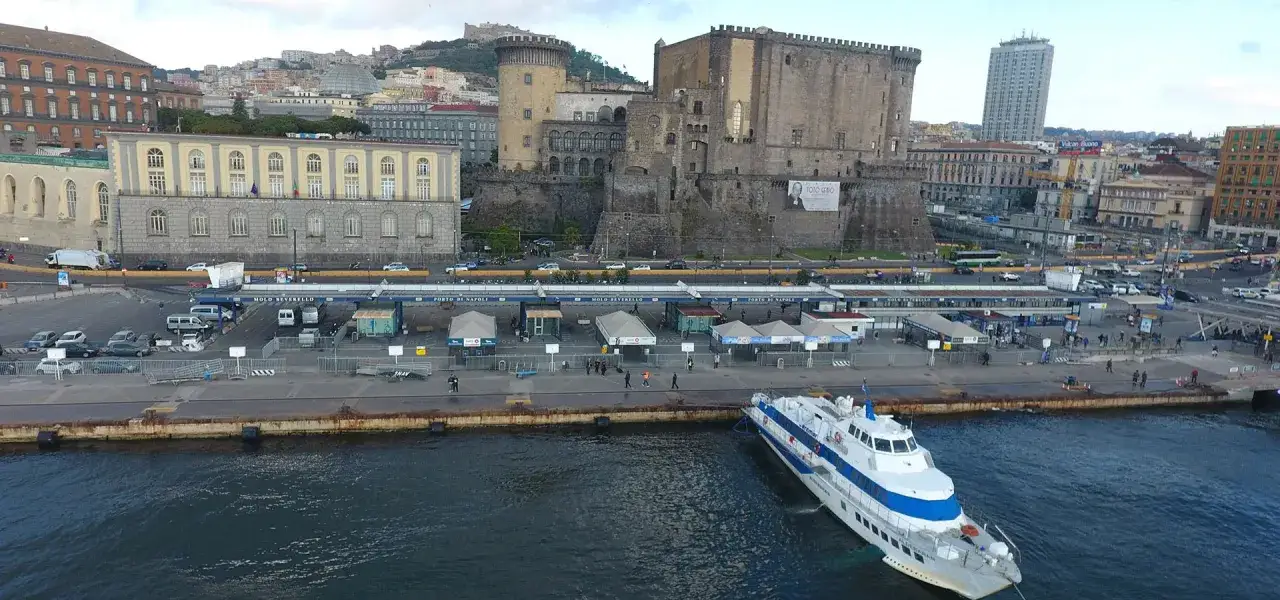 Porto di Napoli, con il Castel Nuovo e un aliscafo pronto per la traversata verso Capri.