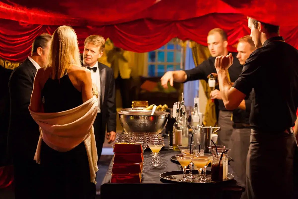 Un apéro James Bond chic avec des cocktails élégants et des invités en tenue de soirée.