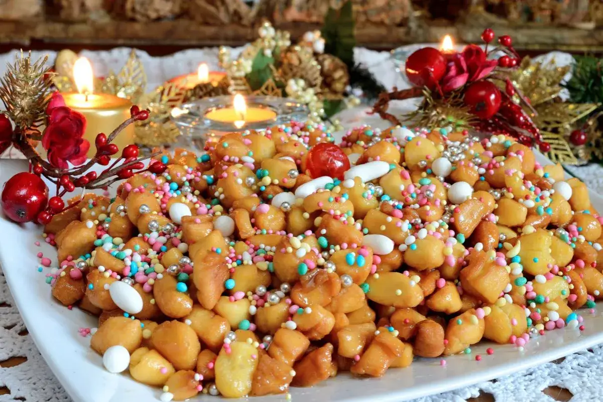 Dolci natalizi colorati, perfetti per quando &egrave; Epifania, con candeline accese e decorazioni festive sullo sfondo.