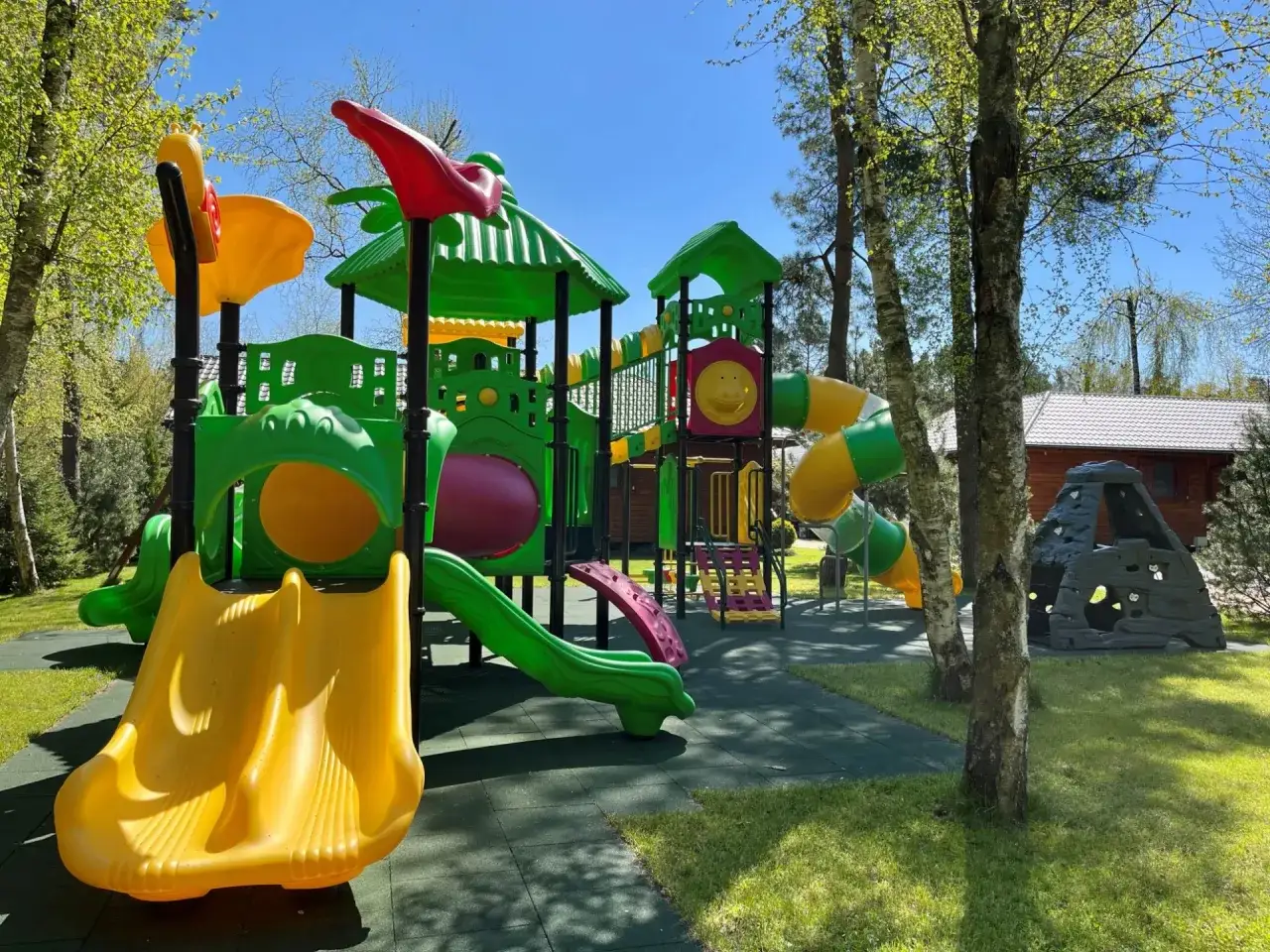 Kolorowy plac zabaw z domkami nad morzem Dziedzic zachęca do zabawy. Zjeżdżalnie, tunele i ścianka wspinaczkowa czekają na dzieci.