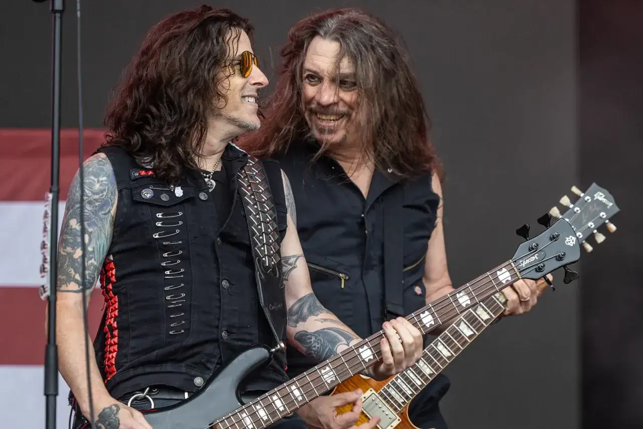 Dwóch muzyków Skid Row, jeden z basem, drugi z gitarą, uśmiecha się do siebie. Czas ich rozebrać!
