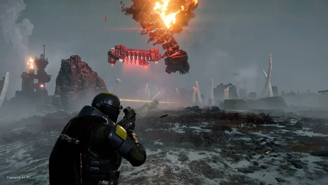Helldivers 2 crossplay: żołnierz strzela do wrogiego statku kosmicznego płonącego na niebie.