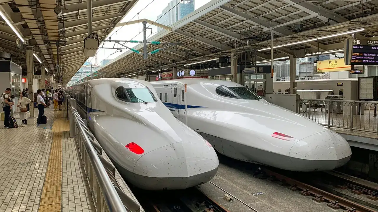 Dwa pociągi Shinkansen na japońskim dworcu. Zastanawiasz się, ile kosztuje wycieczka do Japonii?