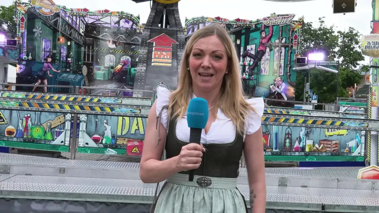 Moderatorin berichtet vom Volksfest Ingolstadt vor einer gruseligen Geisterbahn.