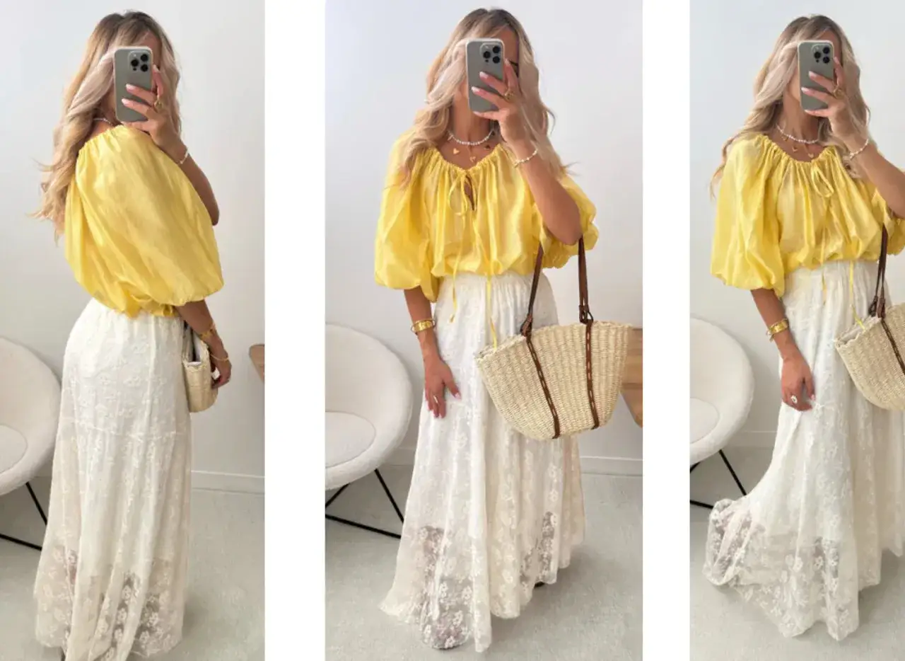 Une femme porte un haut jaune fluide et une jupe longue en dentelle blanche, un look parfait pour savoir comment s'habiller quand il fait chaud femme.