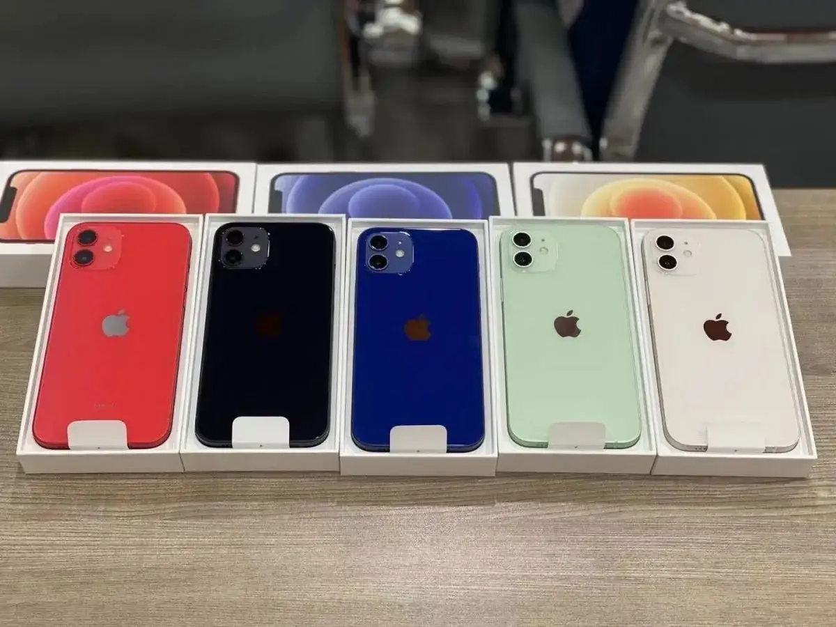 Cinq iPhone 12 dans leurs boîtes : rouge, noir, bleu, vert menthe et blanc. La diversité de couleur iPhone 12 est impressionnante.