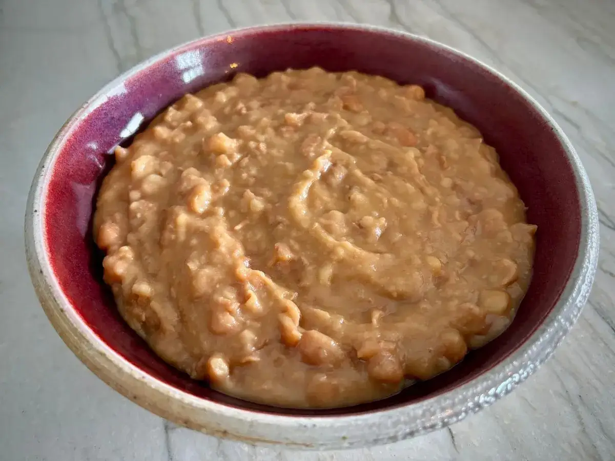 En sk&aring;l med kr&auml;miga refried beans, perfekt f&ouml;r en mexikansk m&aring;ltid.