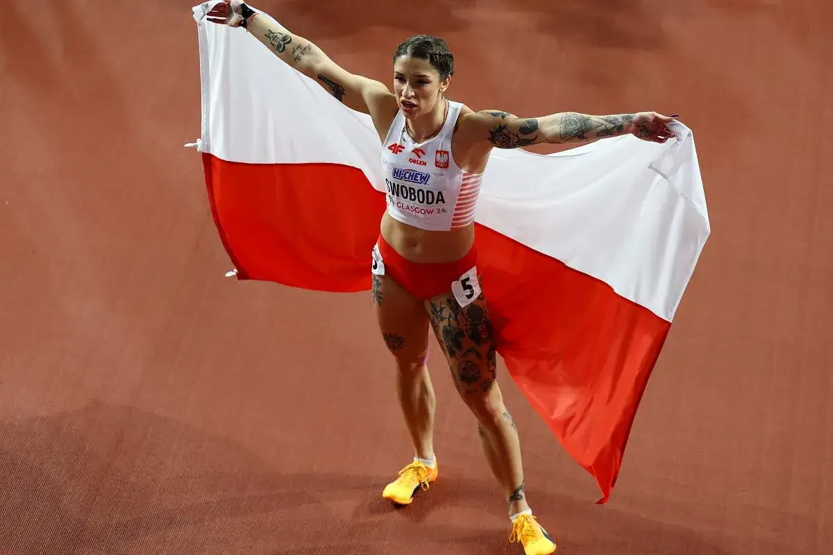 Ewa Swoboda, dumna z biało-czerwonej flagi, świętuje sukces na bieżni.