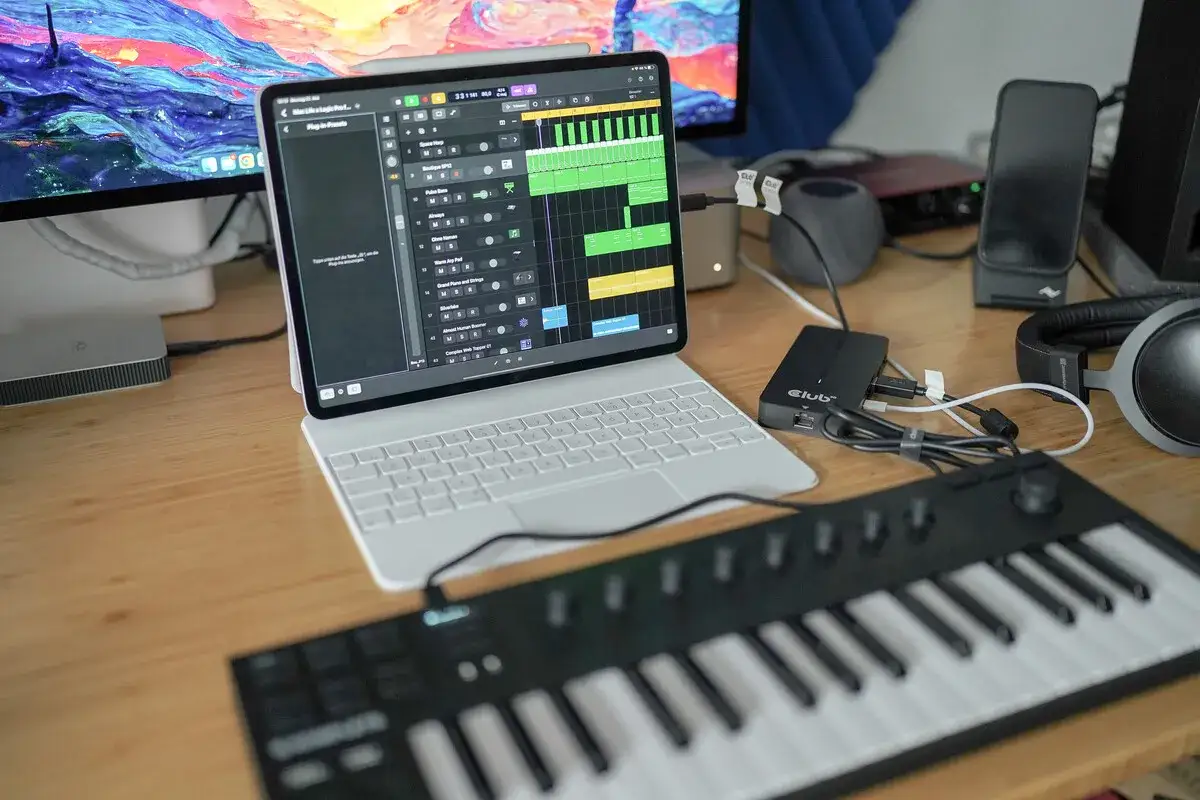 Ein iPad mit Logic Pro und ein MIDI-Keyboard auf einem Holztisch. Perfekt für Musikproduktion unterwegs, mit dem **logic remote** auf dem Tablet.