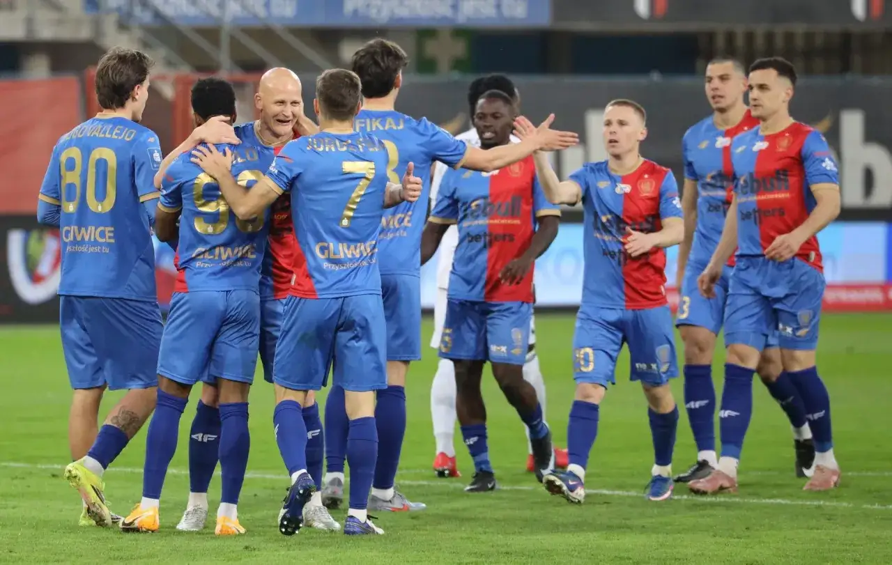 Piast Gliwice świętuje zwycięstwo nad Radomiakiem Radom. Piłkarze w niebieskich strojach cieszą się po meczu.