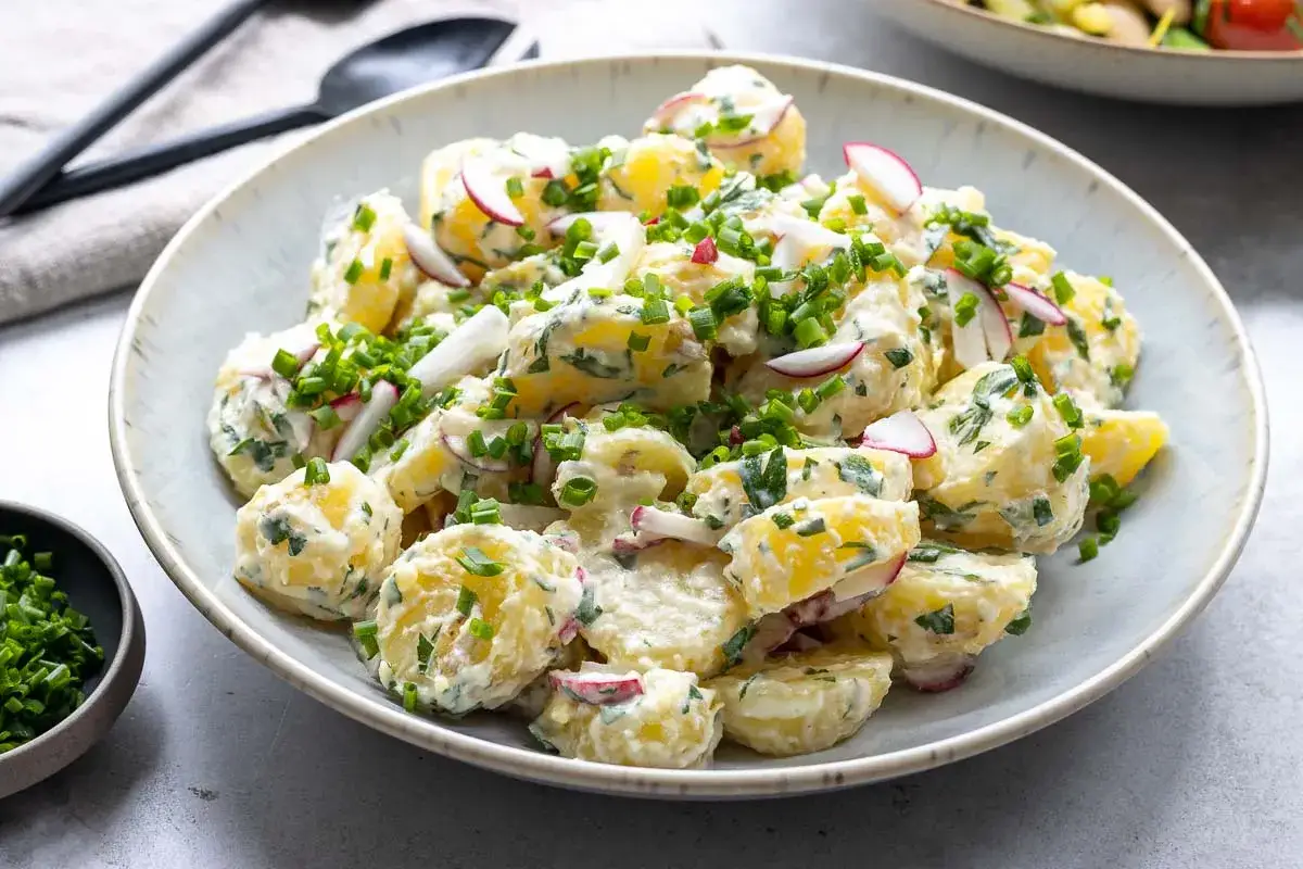 Ein cremiger Kartoffelsalat mit Meerrettich, garniert mit Radieschen und Schnittlauch. Perfekt f&uuml;r ein sommerliches Picknick.