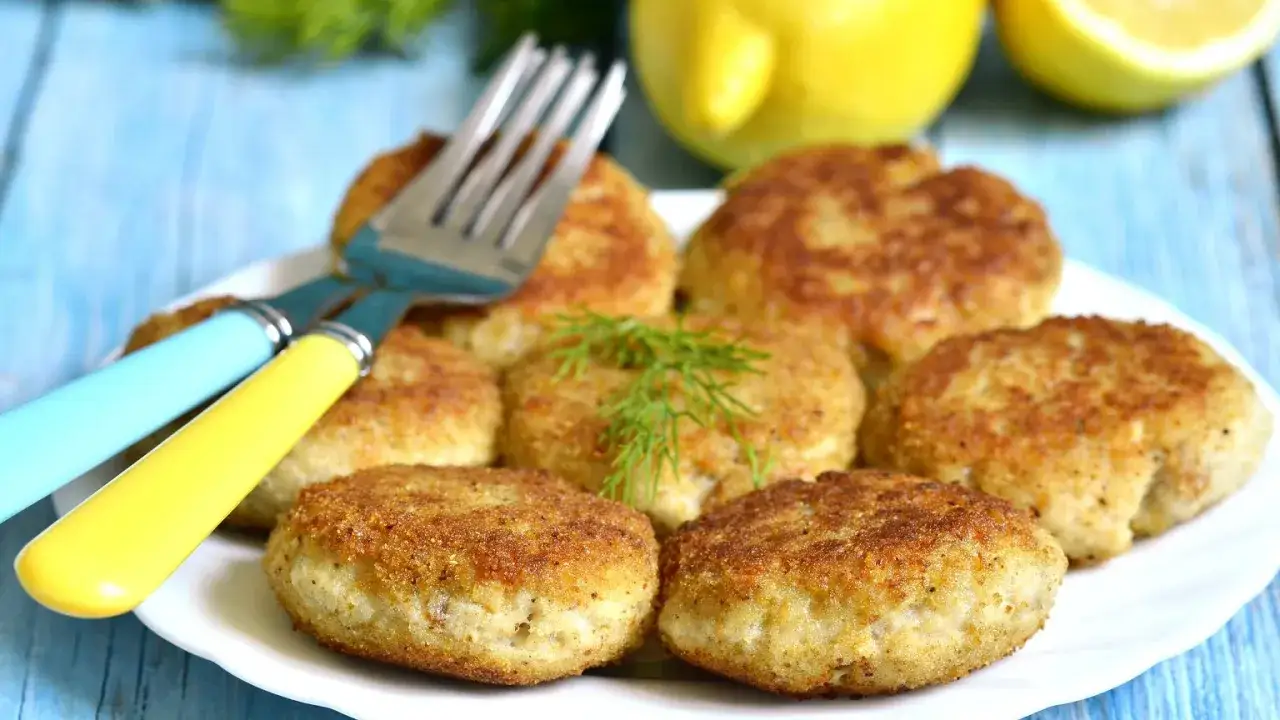 Talerze pełne kotlecików, widelce i cytryny. Czy jedzenie mięsa w piątek to grzech? Smacznego!