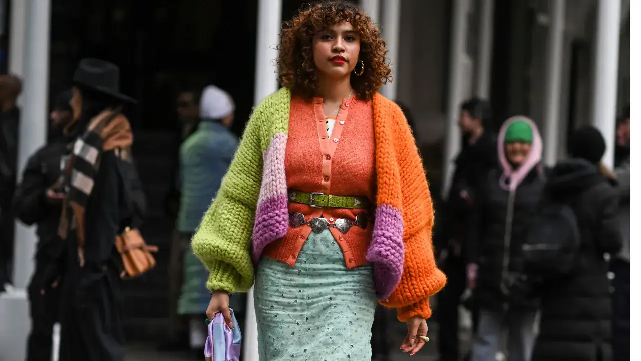 Bunte Strickjacke mit Ballon&auml;rmeln, die zeigt, wie man einen Cardigan kombiniert, Damen tragen dazu mintgr&uuml;nen Rock und auff&auml;lligen G&uuml;rtel.