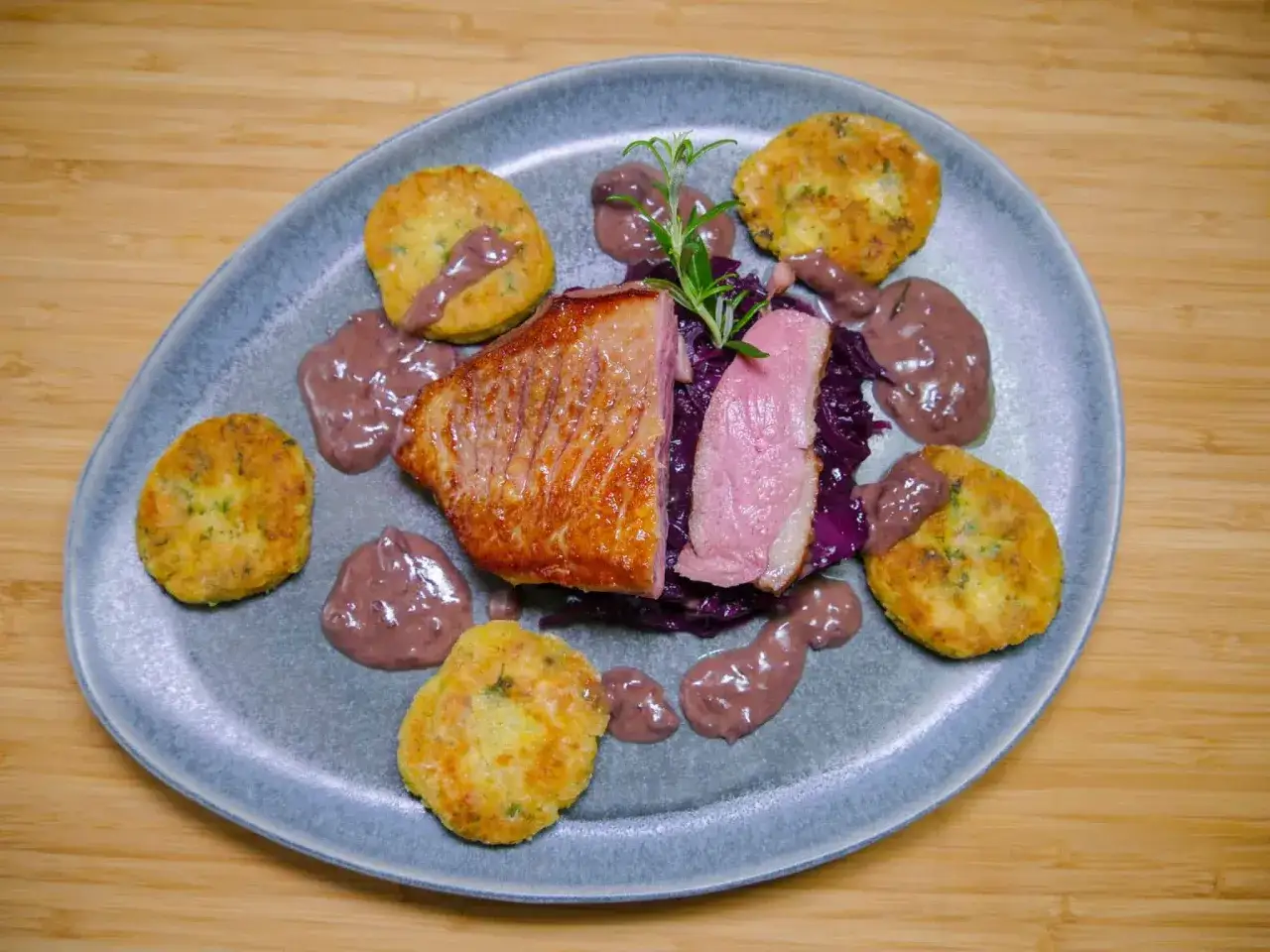 Gebratene Ente auf Rotkohl mit Macaire Kartoffeln und einer dunklen Sauce.