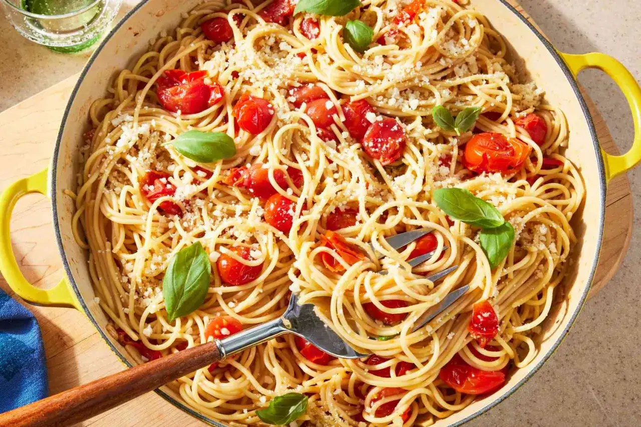 Szybki obiad z makaronem spaghetti, pomidorkami koktajlowymi i bazylią, posypany parmezanem. Idealny na letni wieczór.