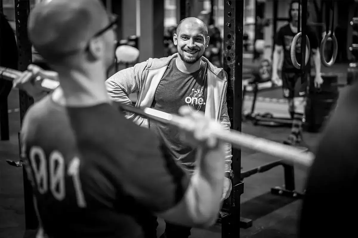 Osoba początkująca trenująca crossfit z trenerem