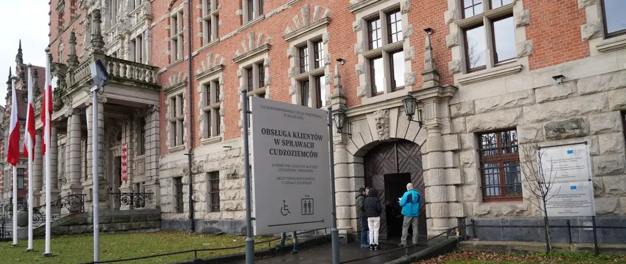 Przed urzędem, gdzie można uzyskać kartę pobytu czasowego, stoi tablica informacyjna.