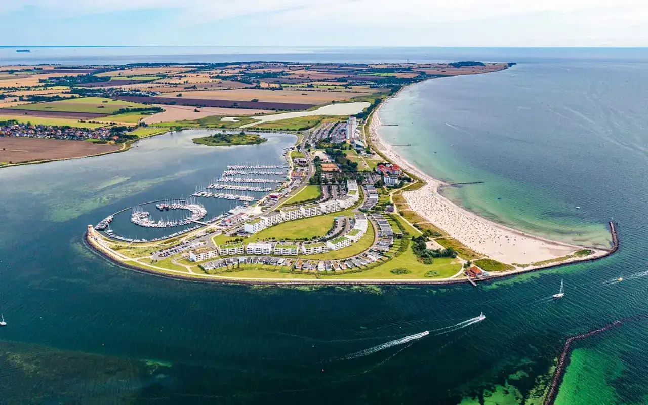 Traumhafter Blick auf die Ostsee mit einem Yachthafen, breitem Sandstrand und Ferienh&auml;usern. Perfekt f&uuml;r einen Urlaub am Meer.