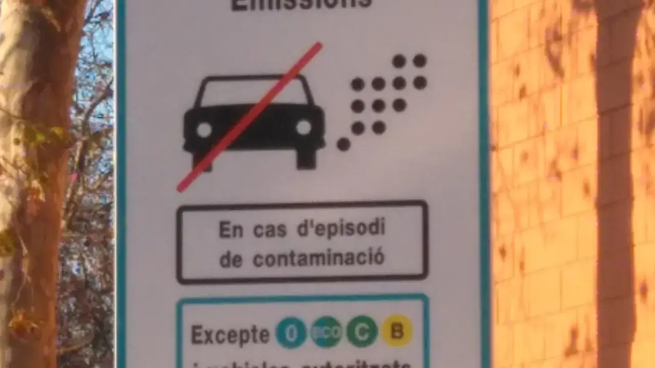 Se&ntilde;al de tr&aacute;fico que indica qu&eacute; quins cotxes poden entrar a Barcelona. Muestra un coche con una l&iacute;nea roja cruzada sobre las emisiones, indicando restricciones.