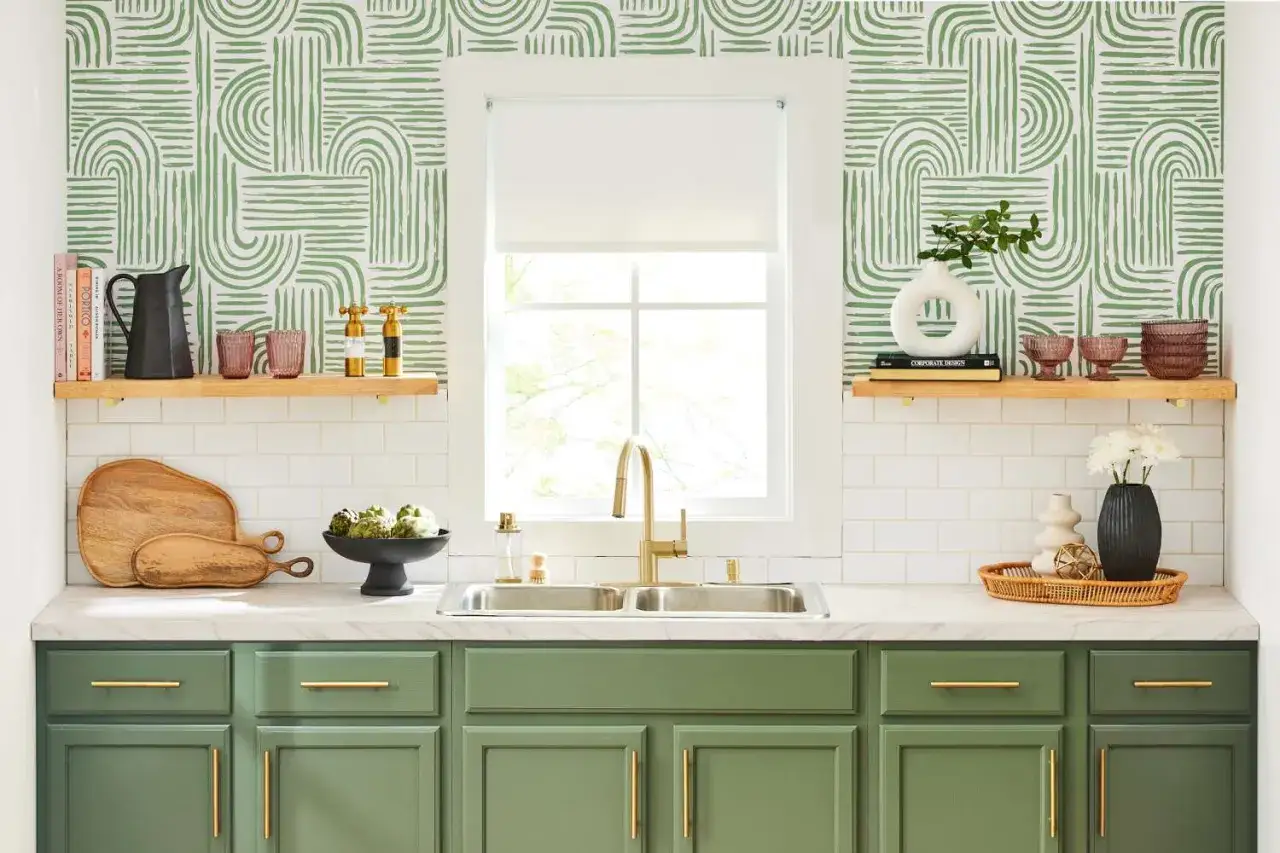 Une cuisine moderne avec des armoires vertes et une **idée tapisserie cuisine** aux motifs géométriques verts.