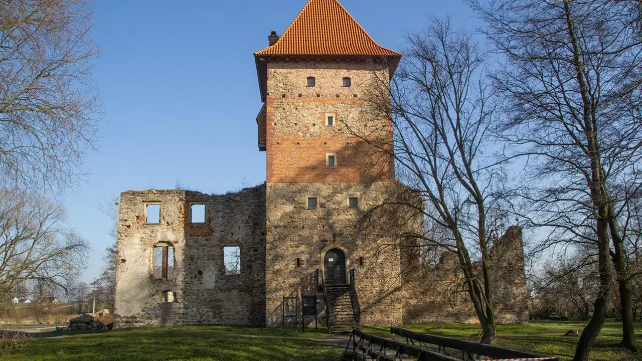Ruiny zamku w Chudowie z wieżą obronną i resztkami murów obwodowych.