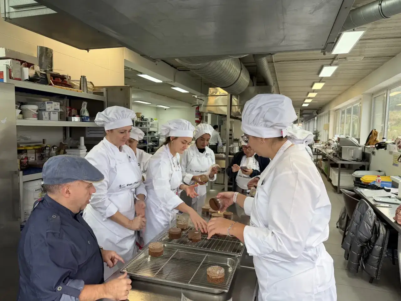 Estudiantes en una clase de reposter&iacute;a decoran pasteles.
