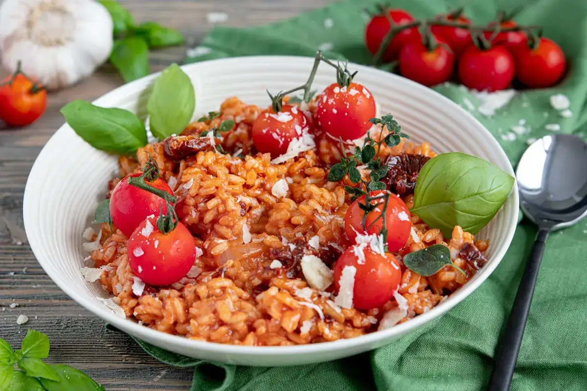 Ein cremiges Tomaten Risotto, garniert mit frischen Kirschtomaten, Basilikum und Parmesan.