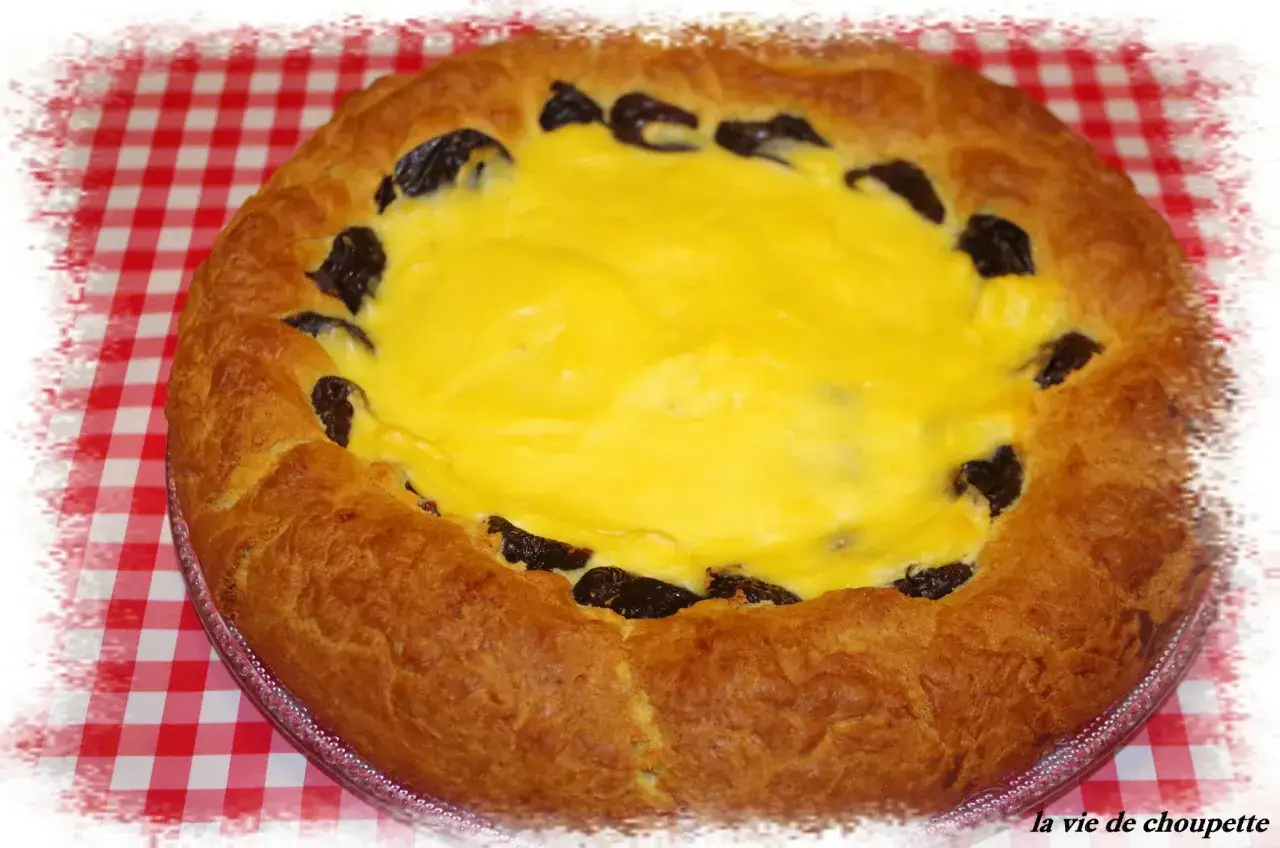 Tarte au libouli dor&eacute;e, garnie d'une cr&egrave;me jaune et de pruneaux, sur un fond &agrave; carreaux rouges et blancs. Un d&eacute;lice !