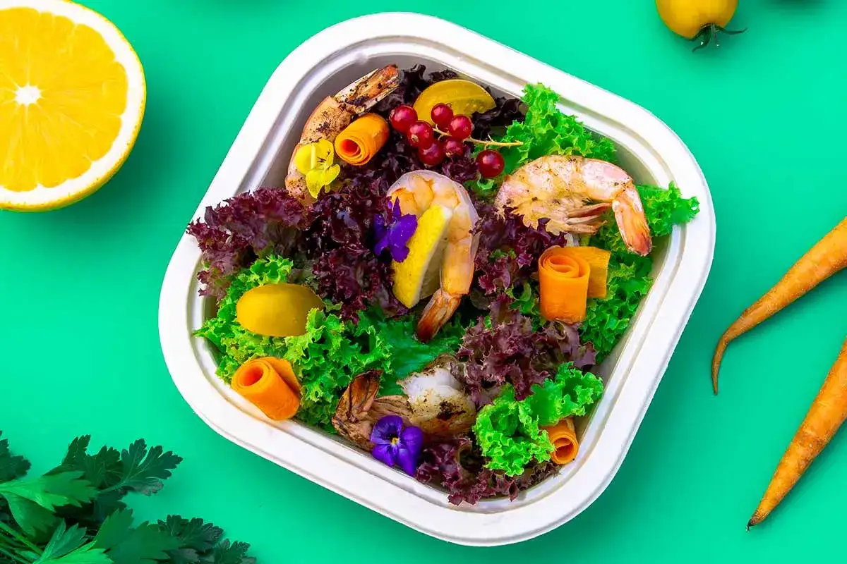 Pyszna dieta pudełkowa niski indeks glikemiczny: krewetki, sałata, marchewka i cytrusy.