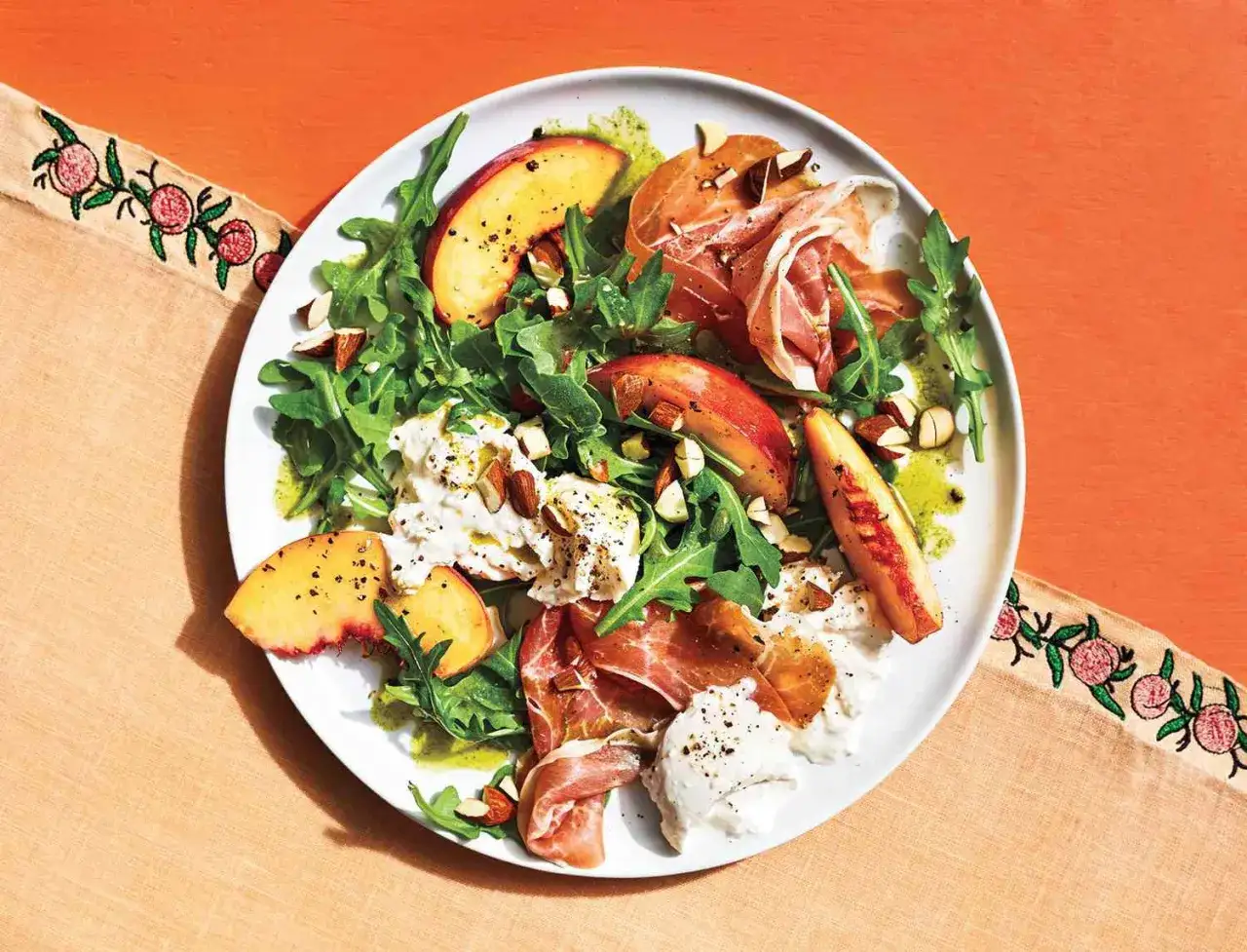 Salat mit Pfirsich, Burrata, Rucola und Prosciutto &ndash; ein k&ouml;stliches Gericht, das zeigt, wie einfach und schnell man leckeres **essen ohne kochen** kann.
