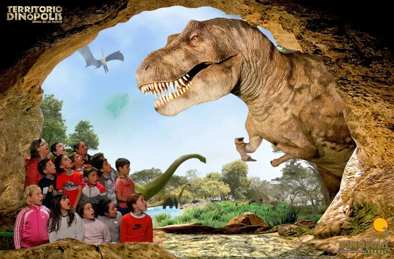 Niños asombrados ante un T-Rex en Dinópolis Zaragoza. Un pterodáctilo vuela sobre un paisaje prehistórico.