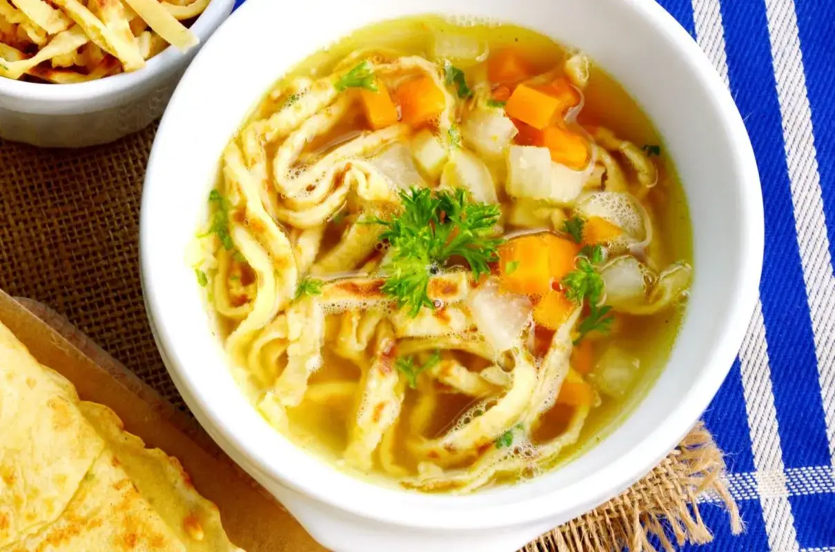 Pyszny rosół z makaronem do rosołu, marchewką i pietruszką. Idealny na chłodne dni.