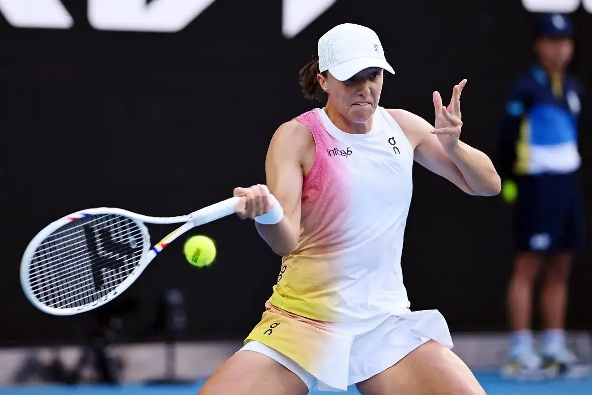 Iga Świątek w akcji podczas Australian Open, skupiona na uderzeniu.