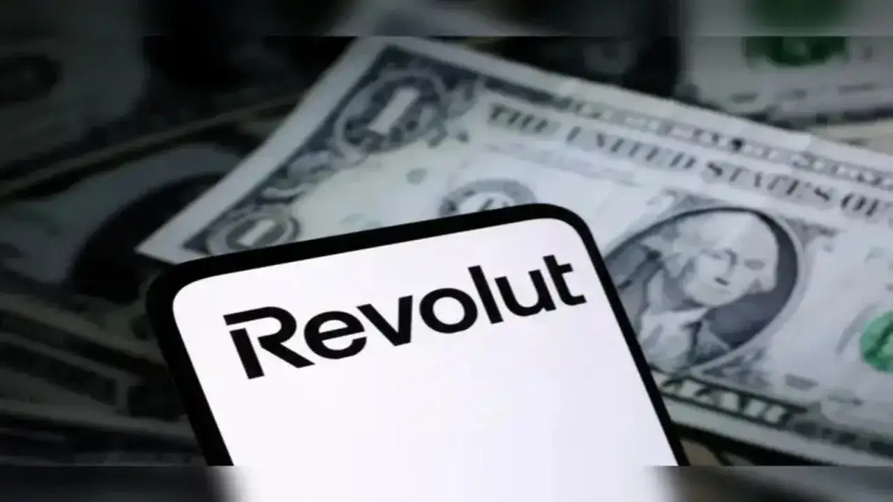 Telefon z logo Revolut na tle banknotów dolarowych. Czy to zapowiedź przyszłego revolut IPO?